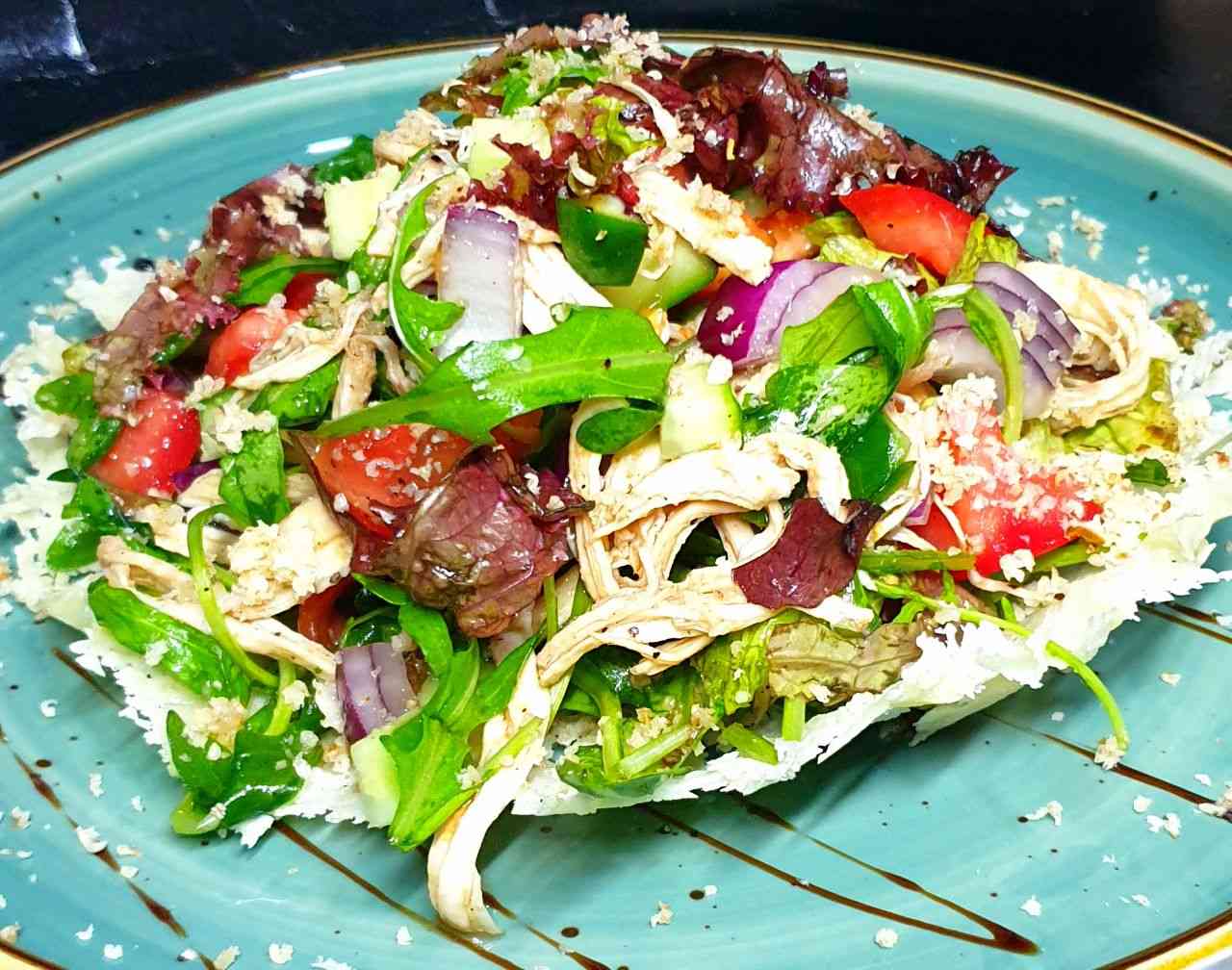 Салат с курицей, овощами на подушке из пармезана